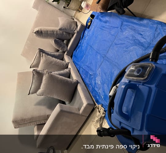מכונת ניקוי כחולה ליד ספה וכיסוי כחול